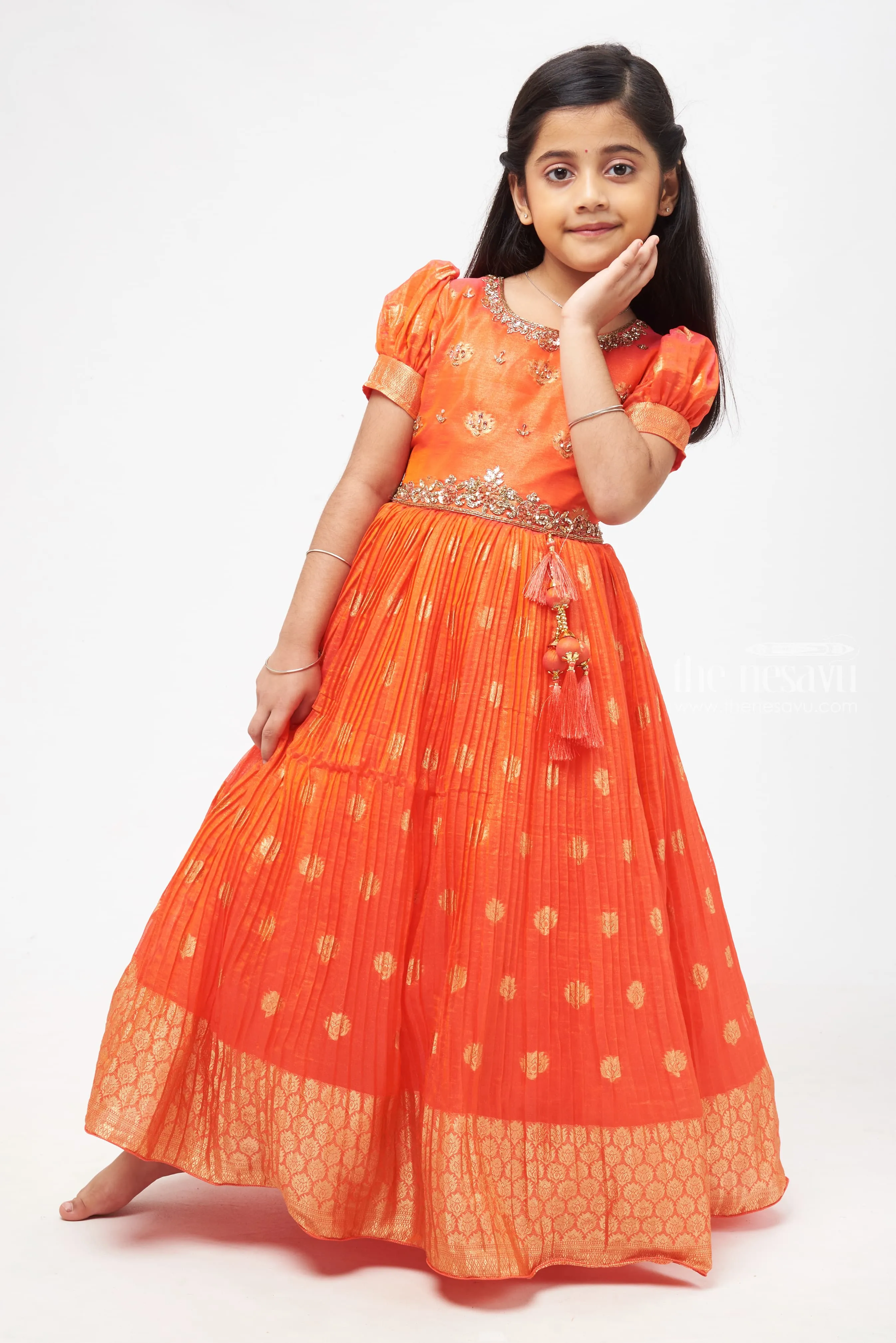 Crimson Elegance: Orange Anarkali with Gilded Accents and Tassel Detailing