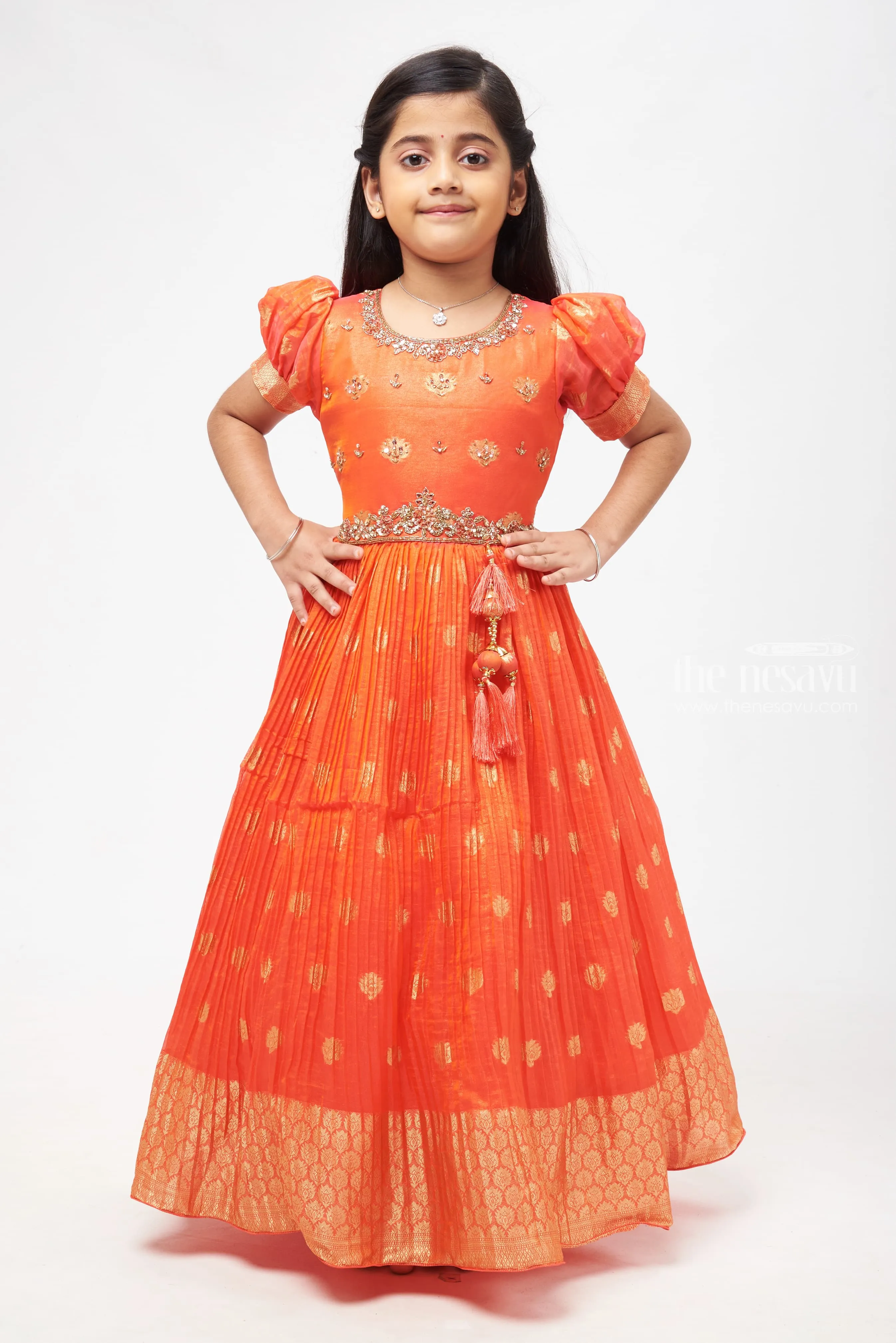 Crimson Elegance: Orange Anarkali with Gilded Accents and Tassel Detailing