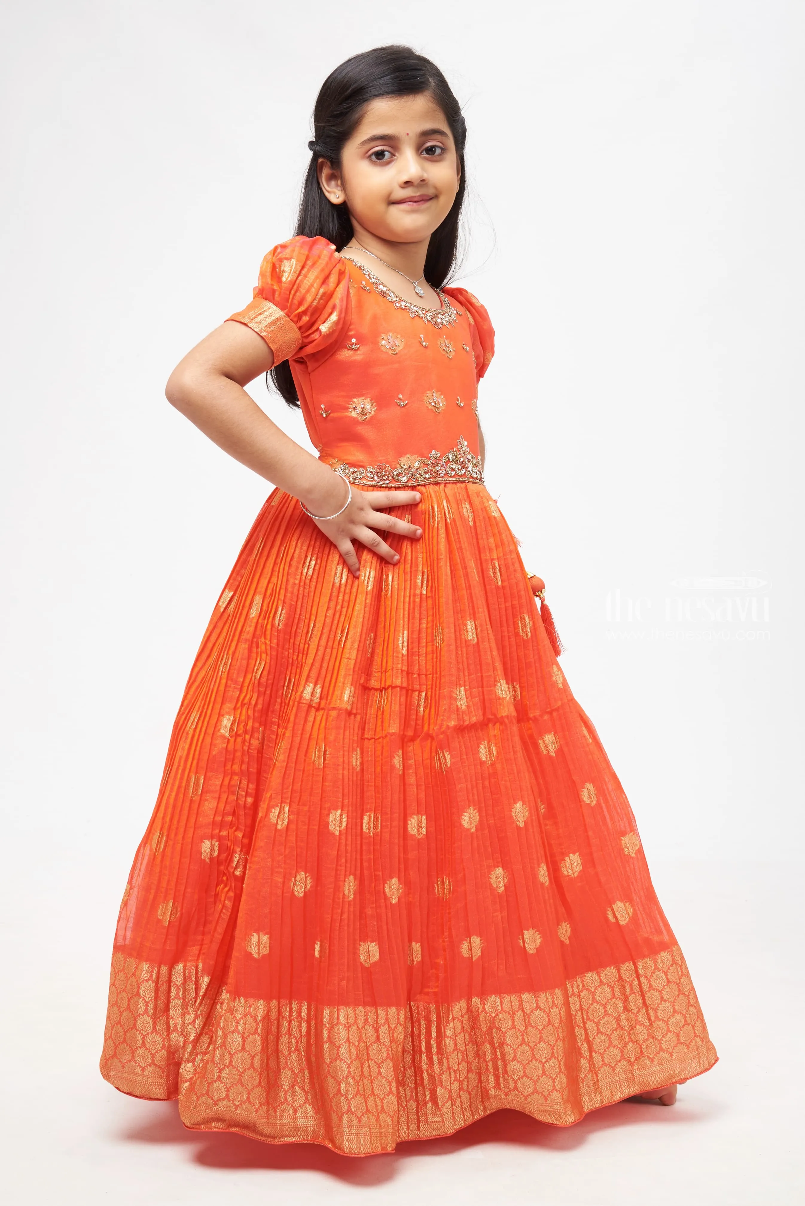 Crimson Elegance: Orange Anarkali with Gilded Accents and Tassel Detailing